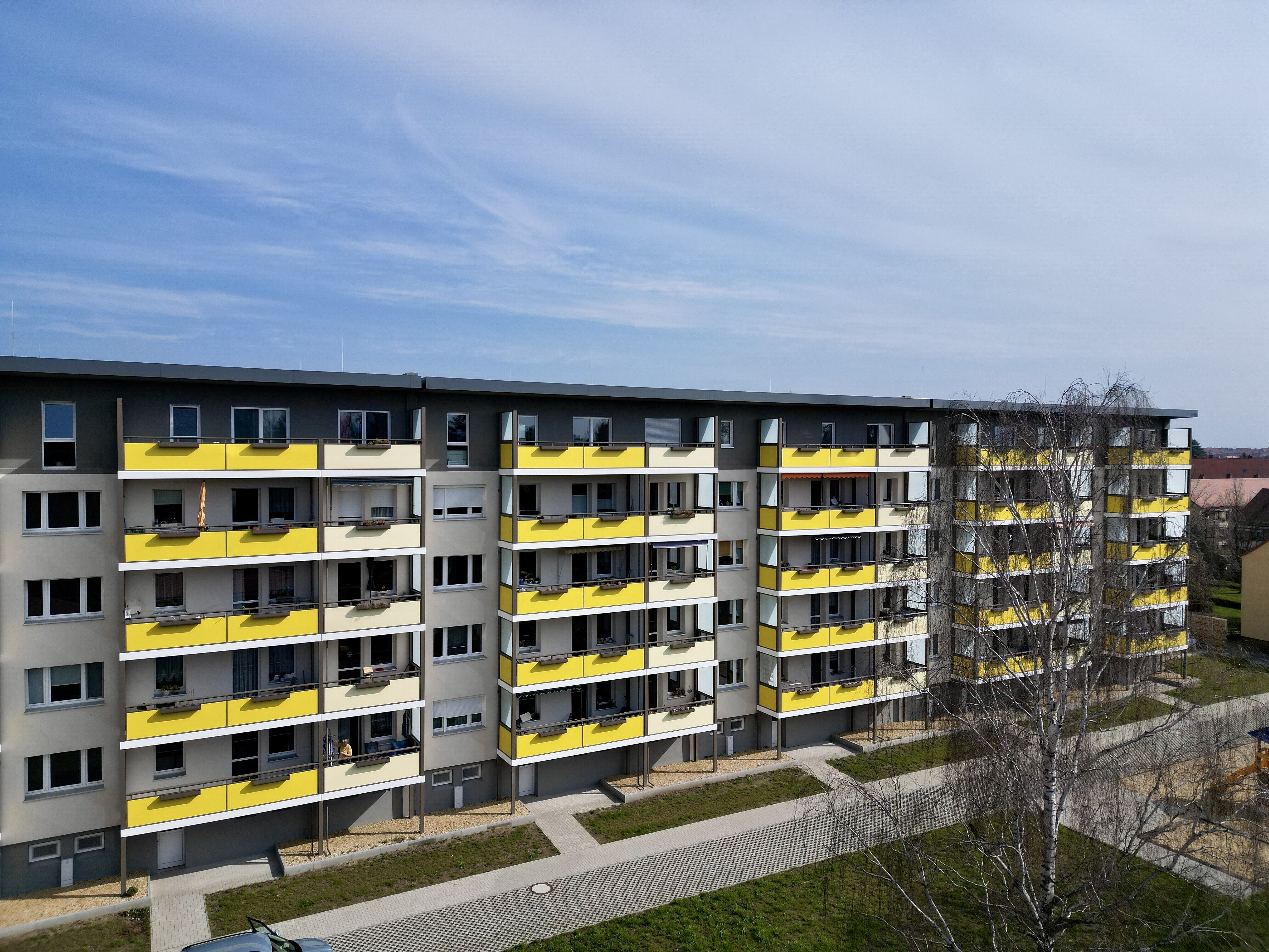 Seitenansicht des durch AIP Görlitz sanierten Wohnblocks auf der Adolph-Kolping-Str. 11-29 in Bautzen, in gelber Farbe 