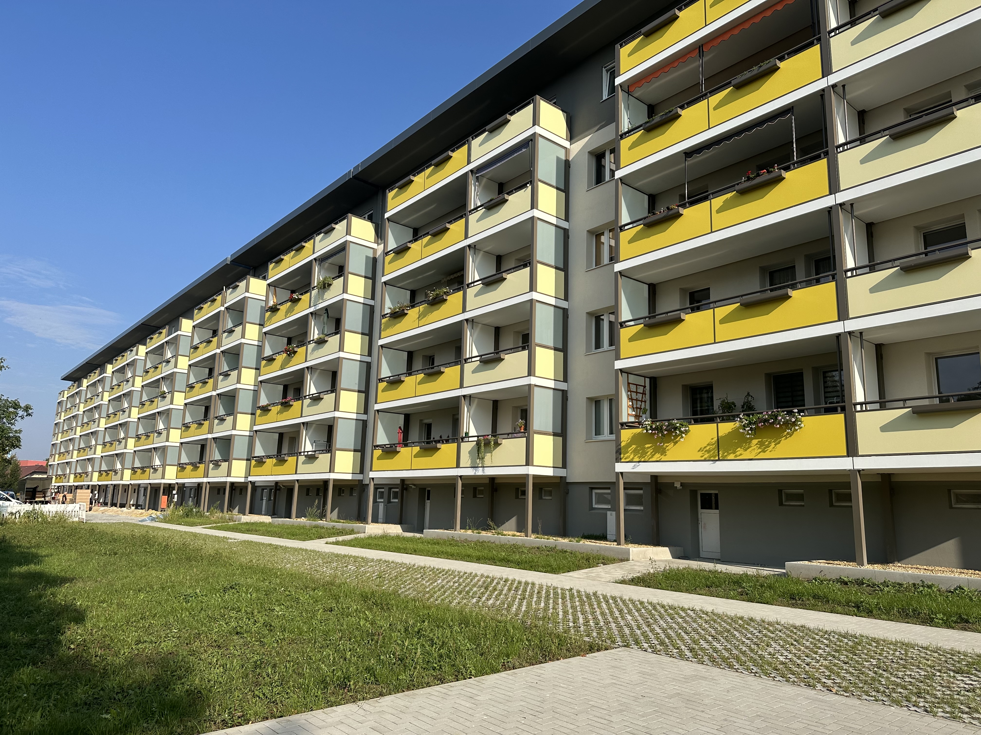 Frontalansicht des durch AIP Görlitz sanierten Wohnblocks auf der Adolph-Kolping-Str. 11-29 in Bautzen, in gelber Farbe 